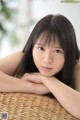 A young woman laying on top of a wicker basket.