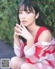 A woman in a red and white dress sitting on the ground.