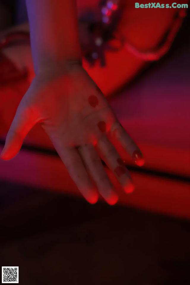 A person's hand is lit up in red light.