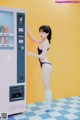 A woman in a bathing suit standing next to a vending machine.