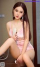 A woman in a pink bathing suit sitting on a desk.